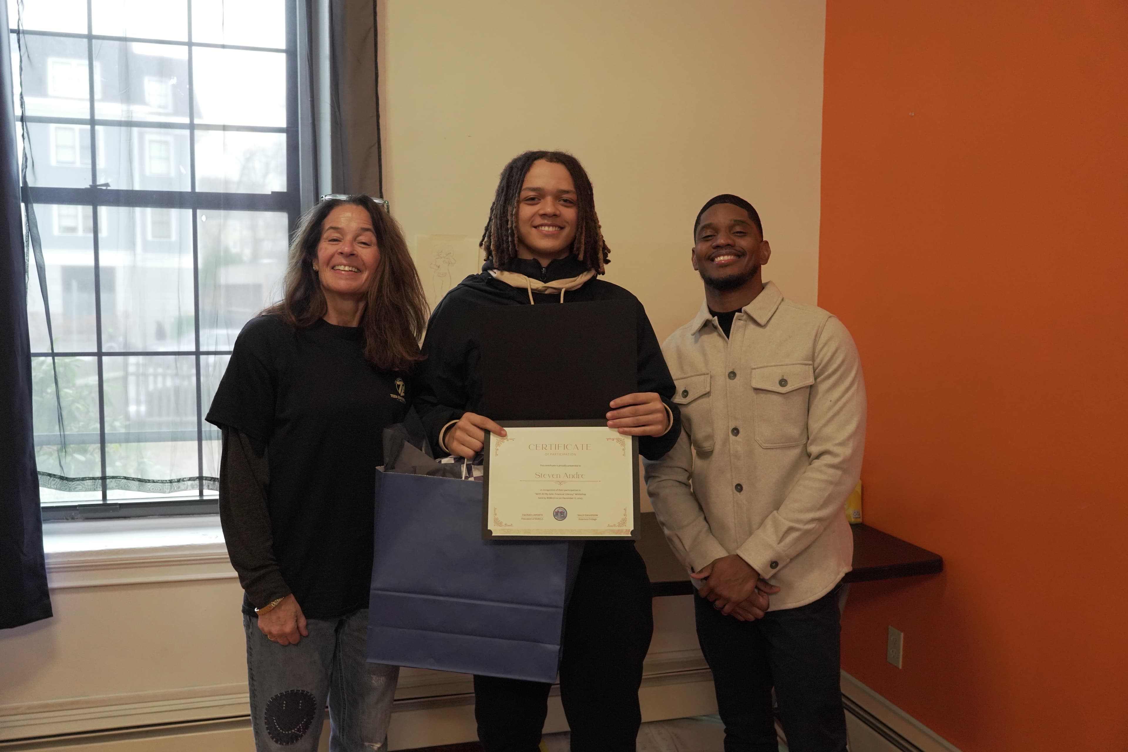A REBELS graduate receiving their certificate at the cohort celebration