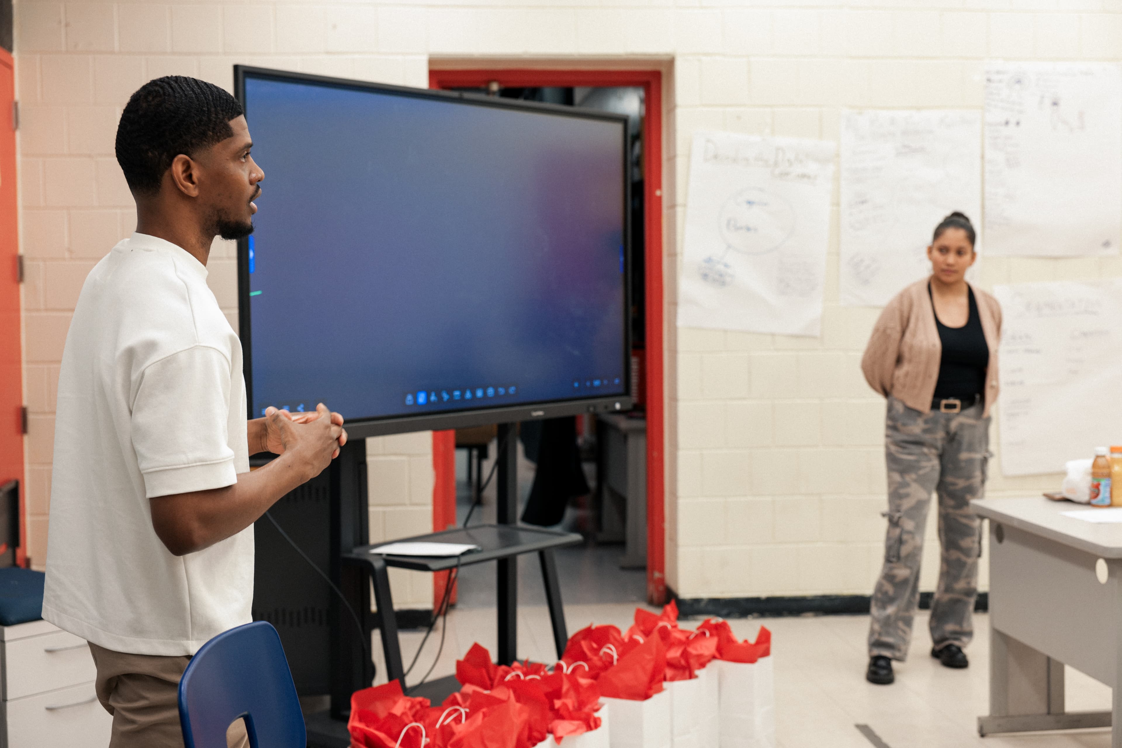 A REBELS facilitator working through a financial concept on the whiteboard with a student
